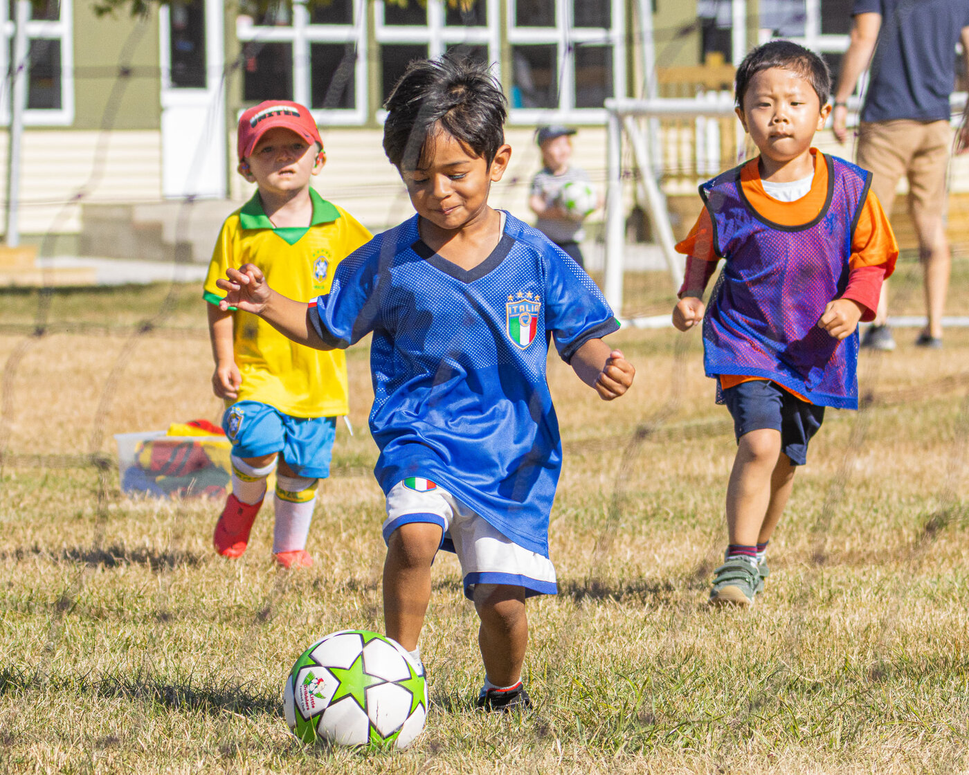 Middle Dribblers running after a green-star Little Dribblers football