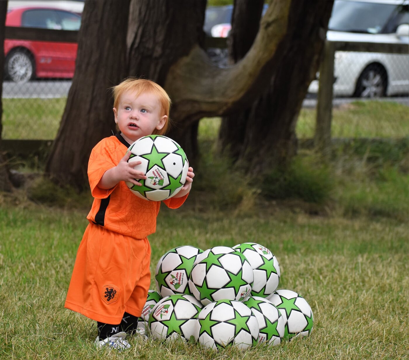 A Very Little Dribbler holding a green-star Little Dribblers football